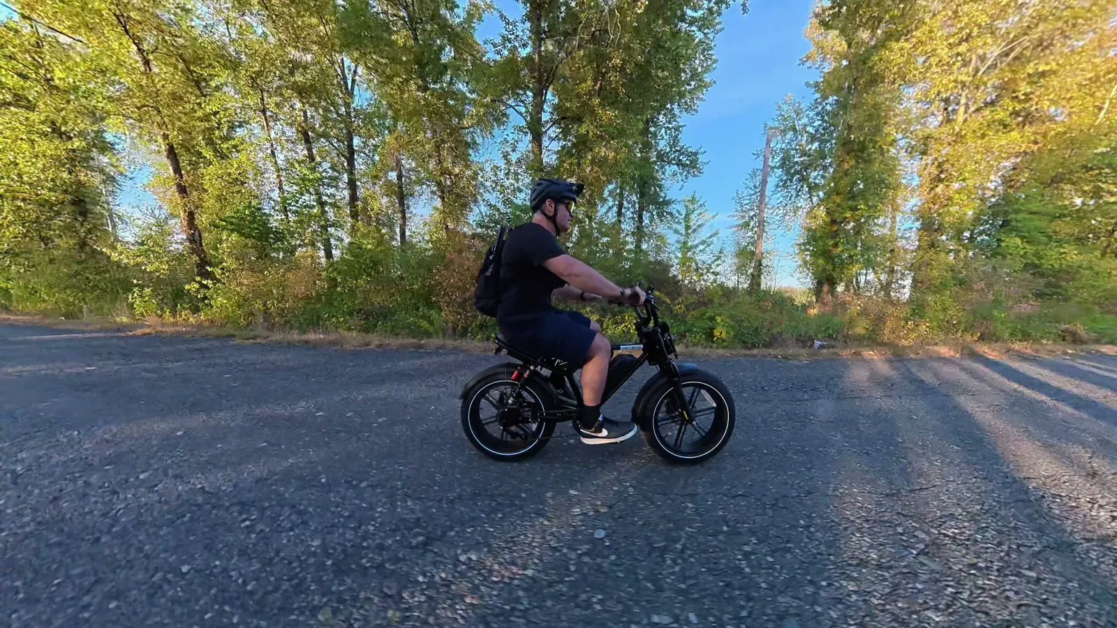 Ben riding the Heybike Titan along a tree-lined path, seen from the side