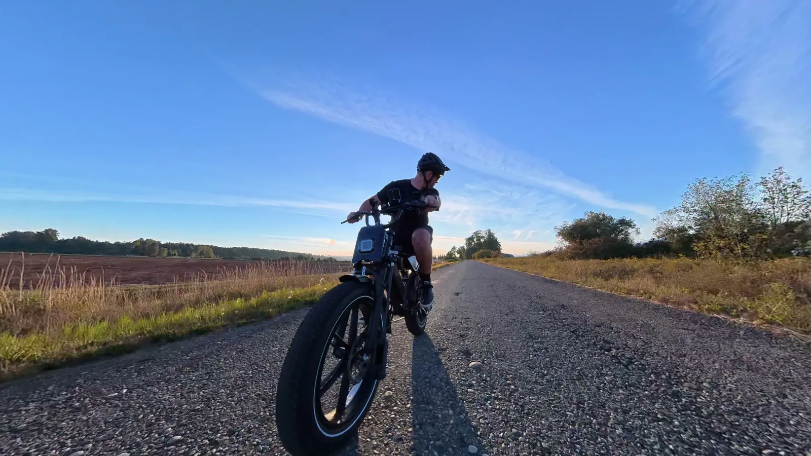 Ben riding the Heybike Titan toward the camera on a farm road