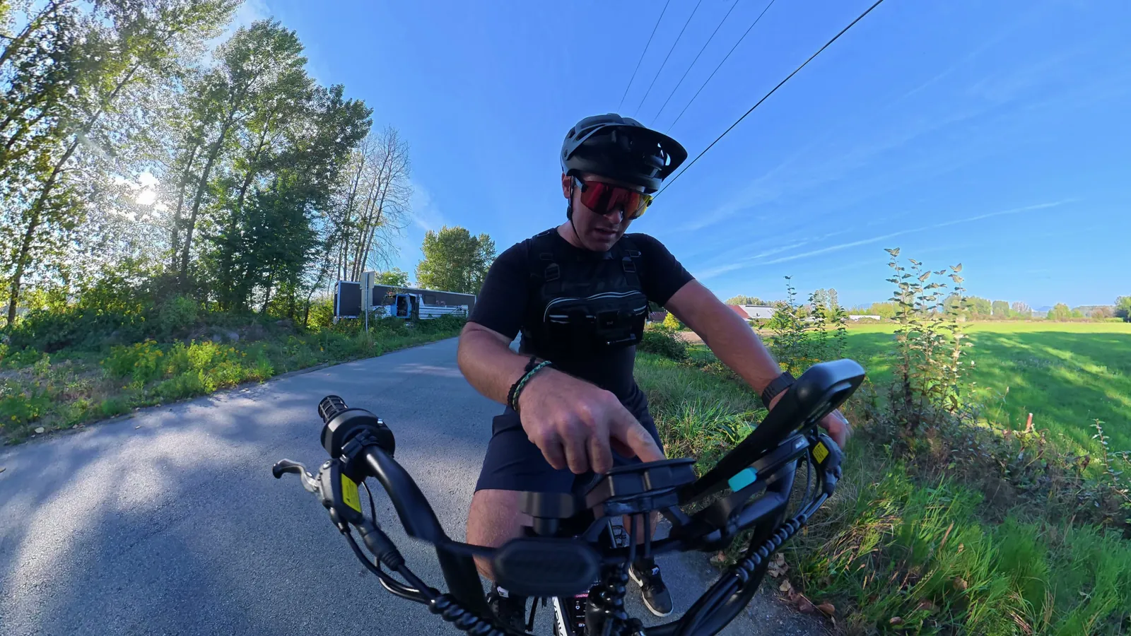Handlebar camera view of Ben riding the Heybike Titan past a green field