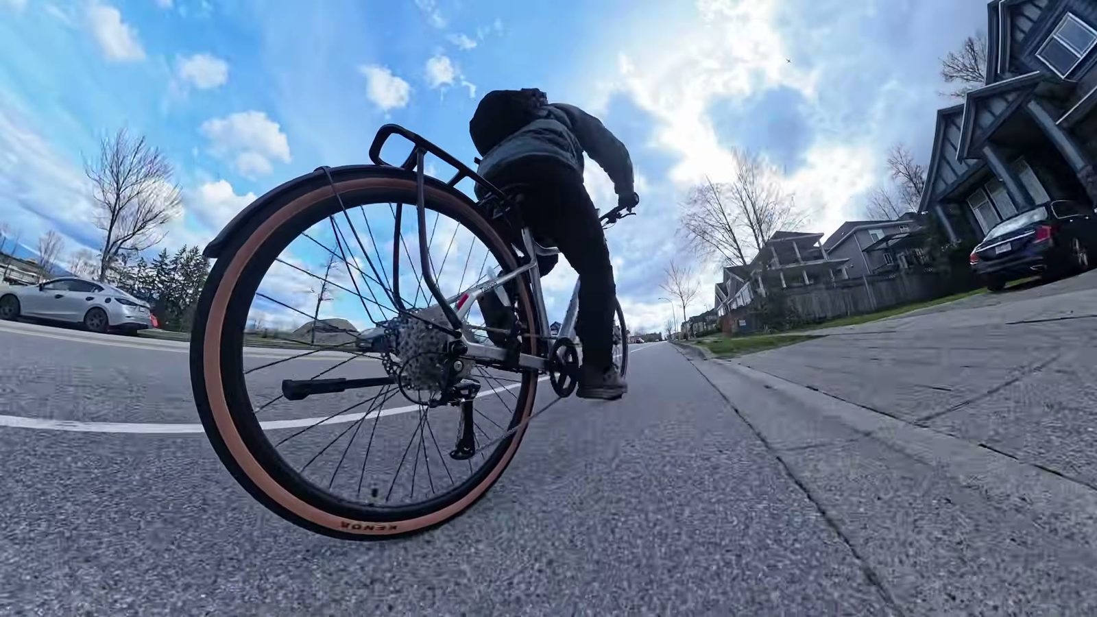 Riding the Velotric Tempo down a residential street, low fisheye angle on the rear wheel and rack