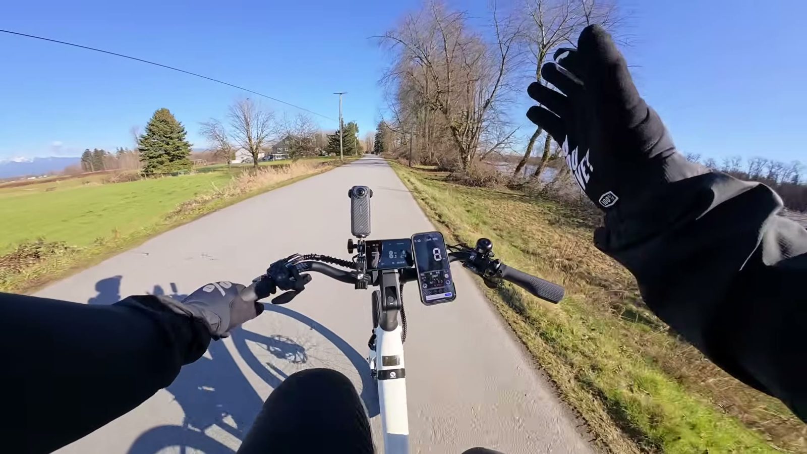 Rider point of view with a hand off the bars while the Breeze 1 glides down a path